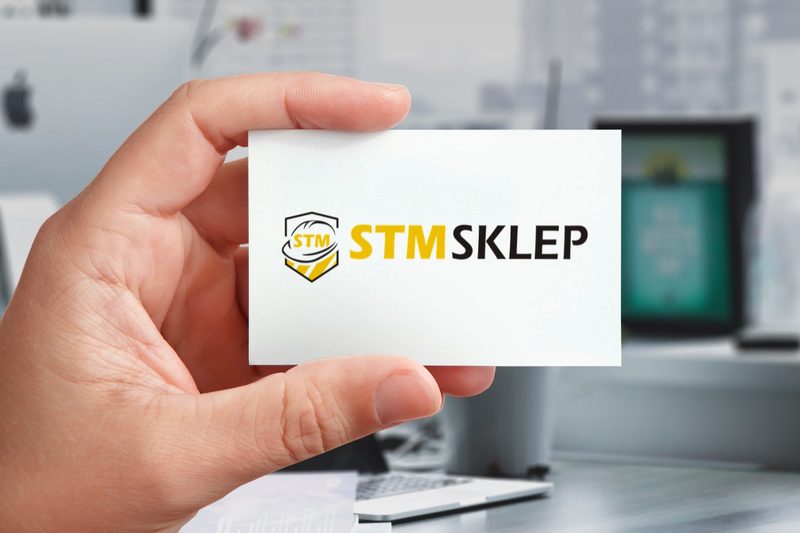 Logo STM Sklep na wizytówce trzymanej w dłoni